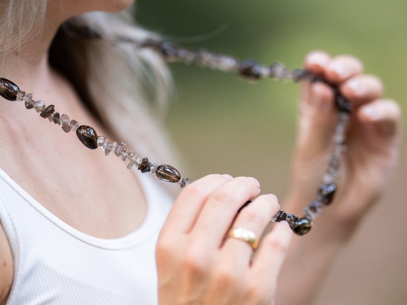 Eine Kette aus Edelsteinen in den Händen