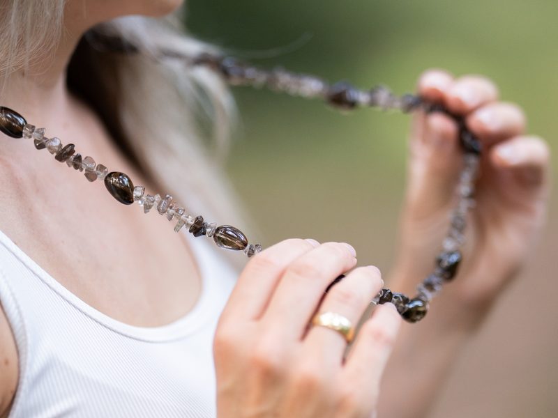 Eine Kette aus Edelsteinen, in den Händen gehalten